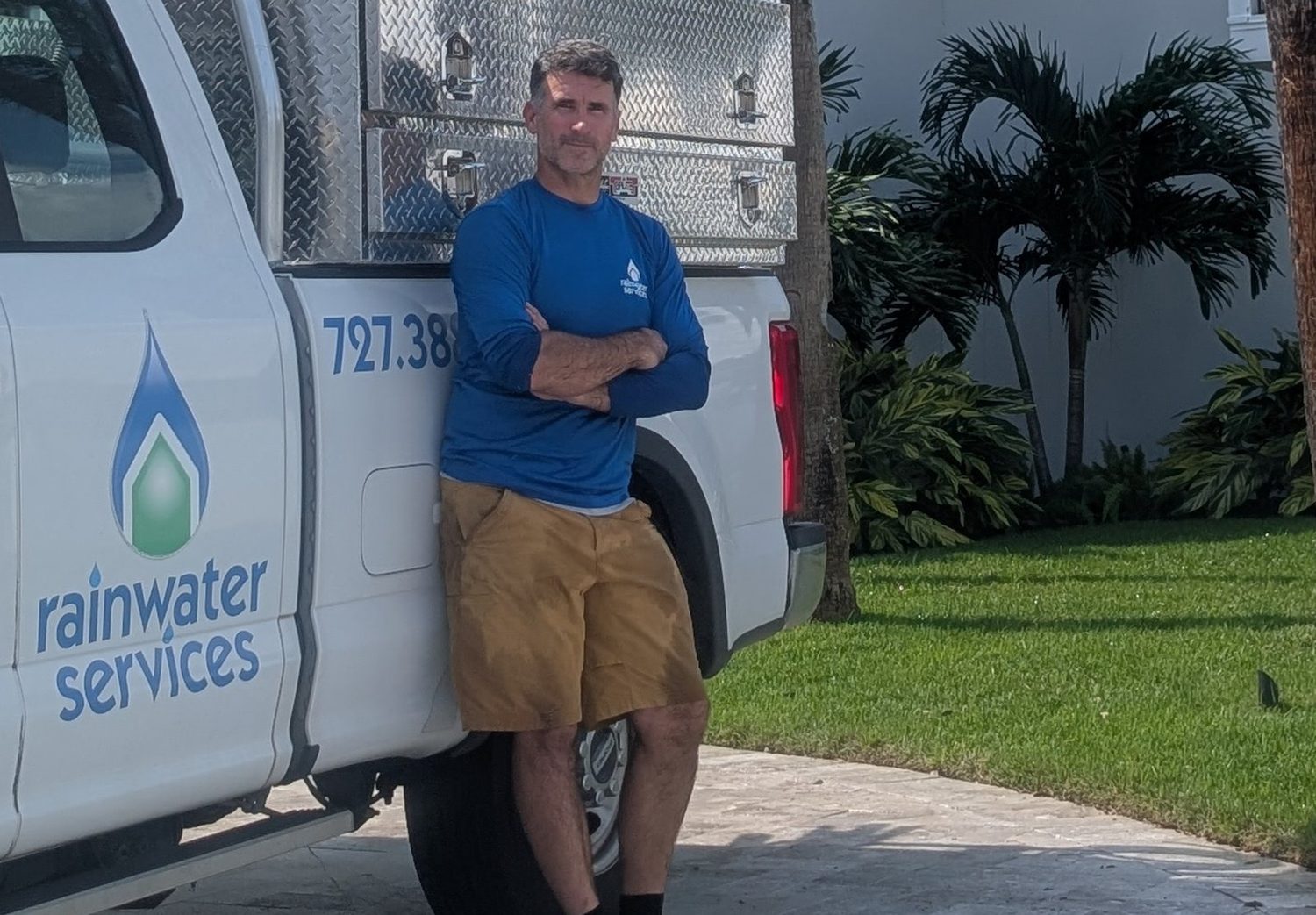 Brian beside a Rainwater Services truck at a customer property